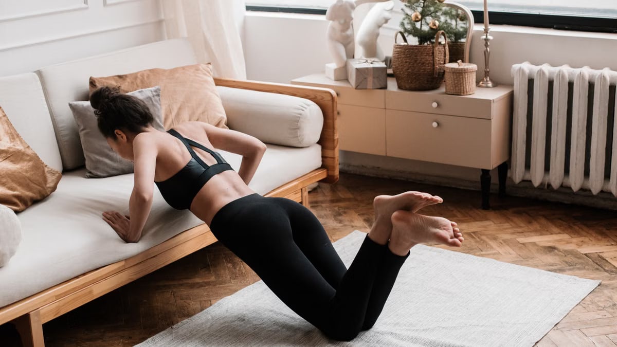 A woman stretches on a mat in a stylish living room, promoting a healthy lifestyle.